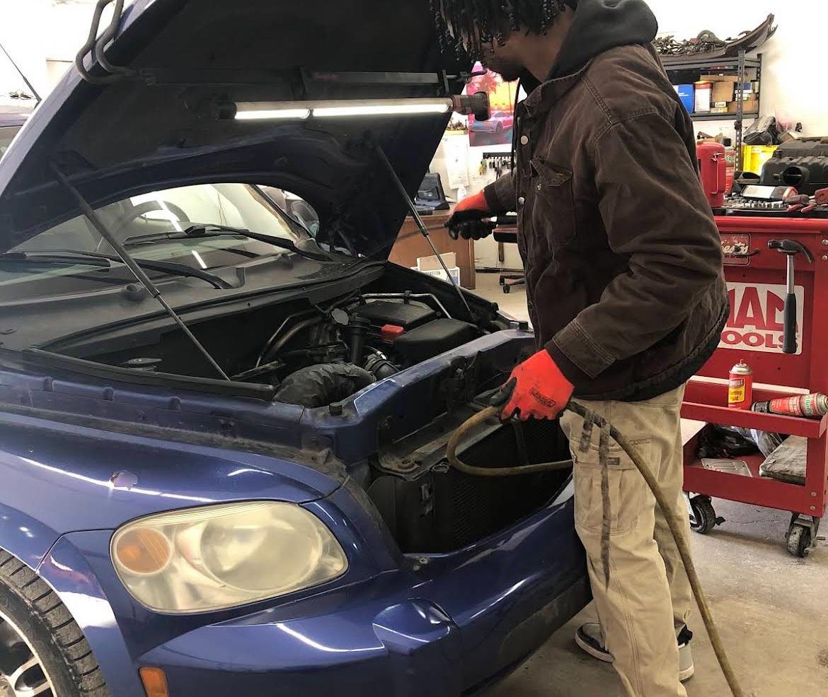 A mechanic at Avon Auto & Diesel working under the hood